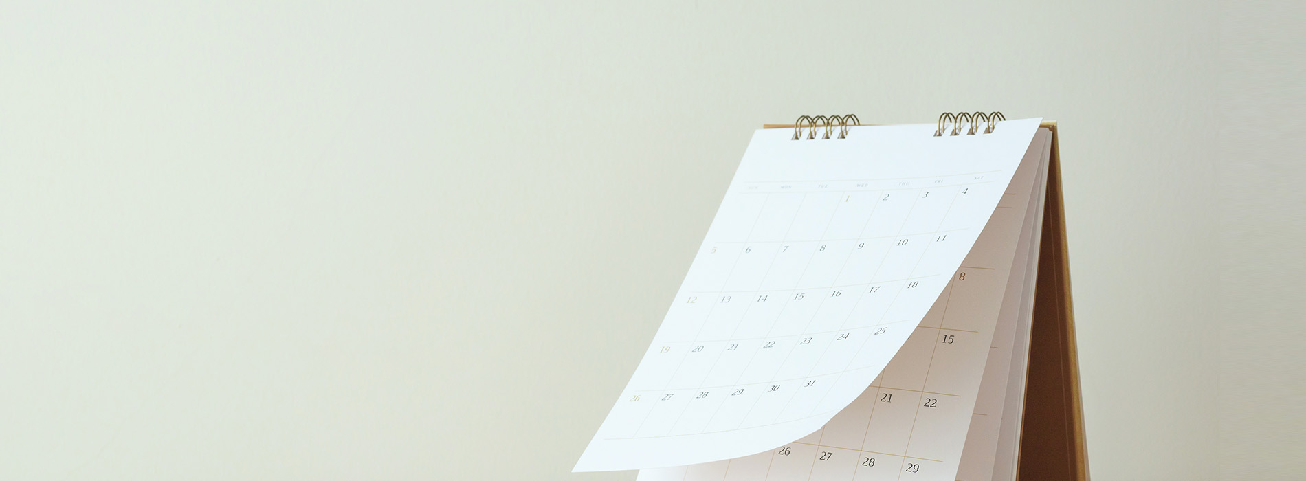 The image shows a calendar folded into an accordion-style stand, with a blank wall in the background.
