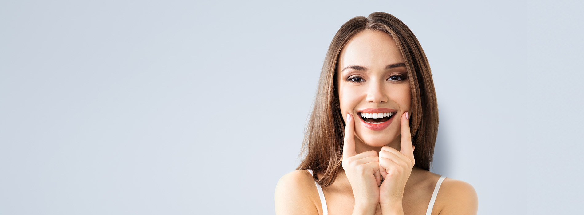 The image features a woman with long hair smiling at the camera, with her hand near her face.