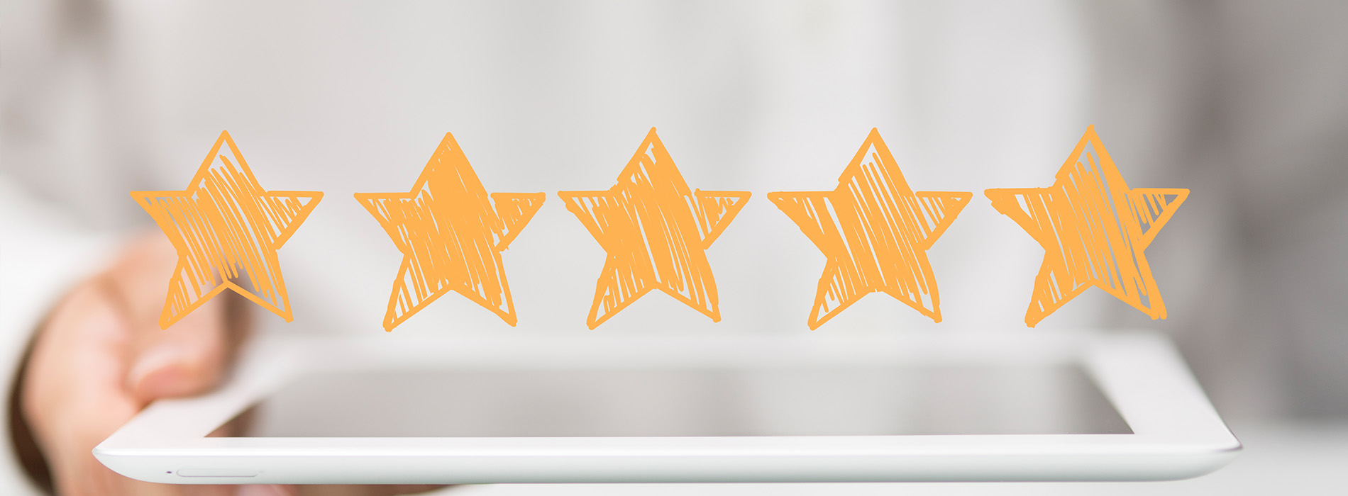 The image shows a hand holding a tablet with five orange star icons on top, suggesting positive feedback or ratings.
