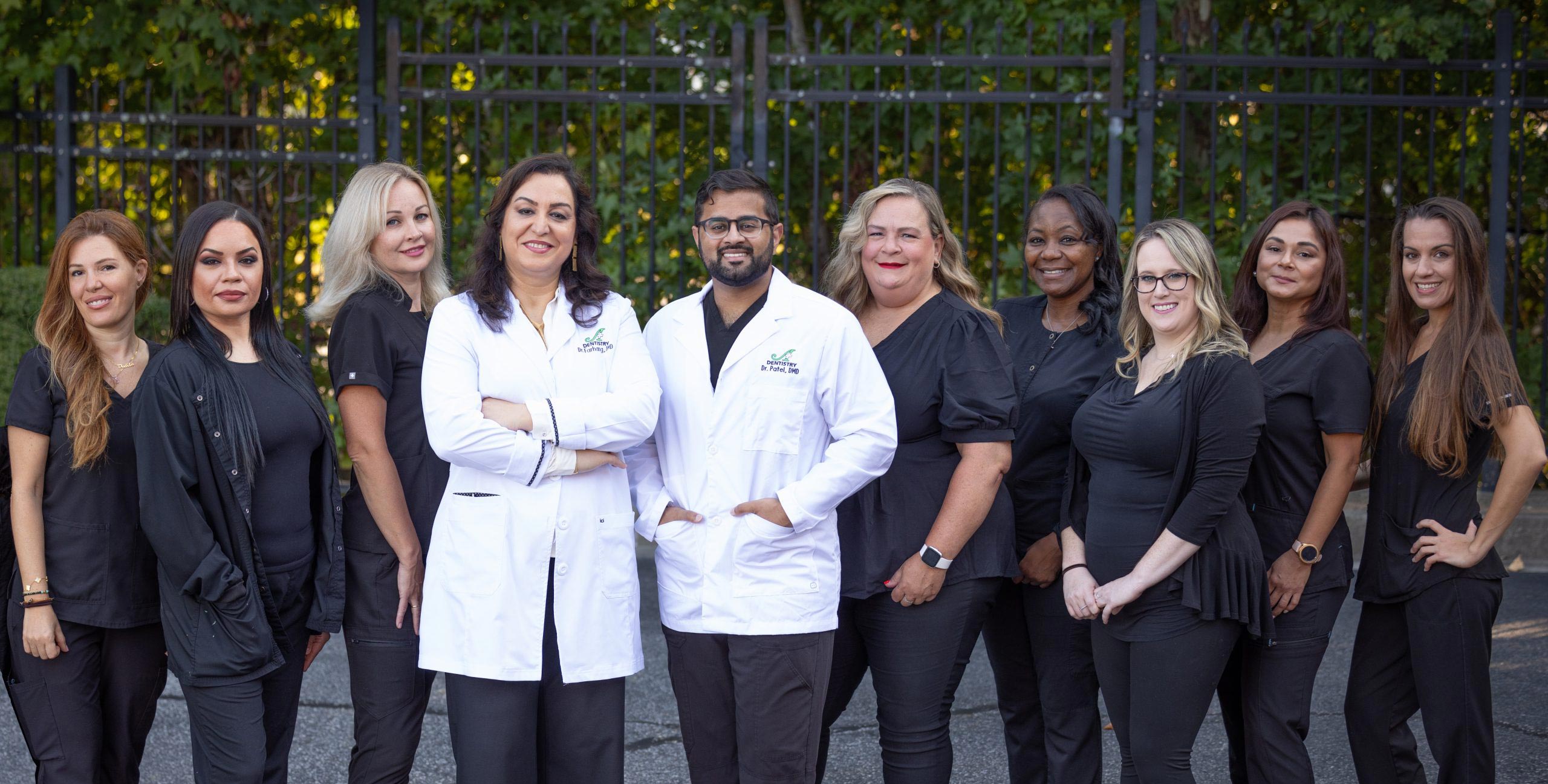 A group of people posing together, with some wearing white lab coats, suggesting they are medical professionals, possibly at a formal event or gathering.