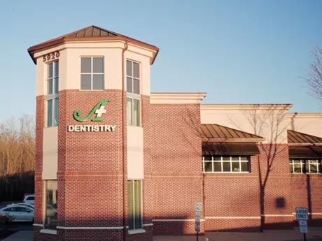 The image shows a building with a sign that reads  Dentistry  outside, indicating it s a dental clinic.