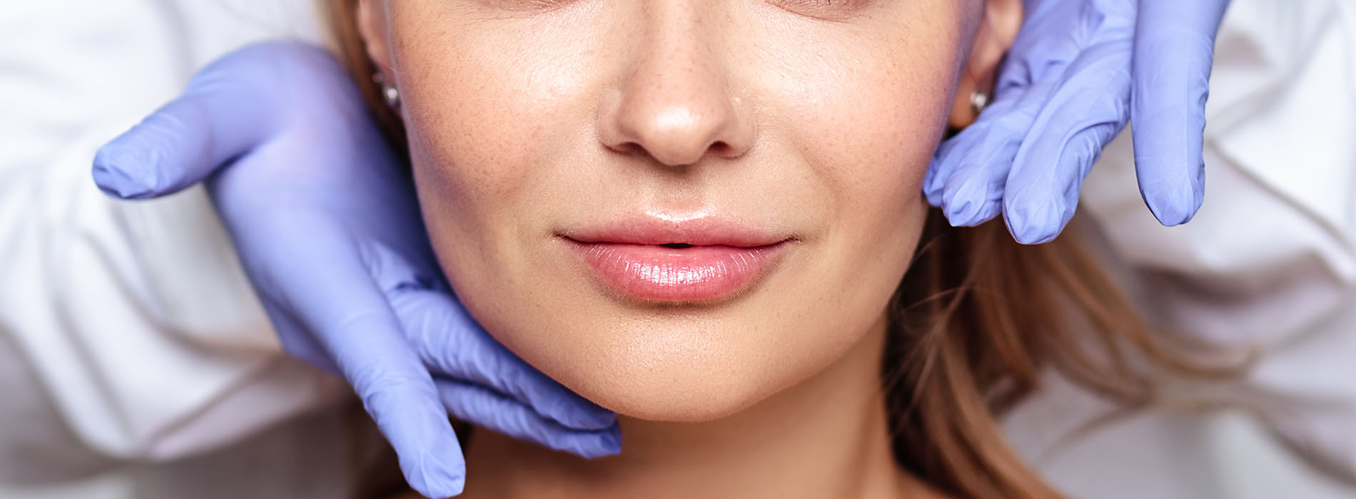 The image shows a person with a medical mask covering their face, sitting in front of a mirror, with a focus on a close-up of their lips and facial features.
