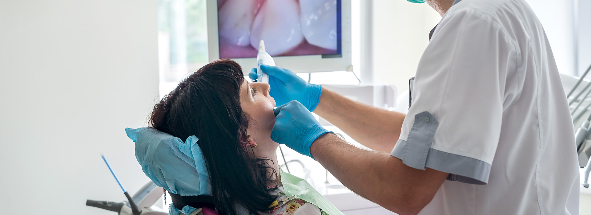 A dental professional performing an oral procedure on a patient with visible dental tools.