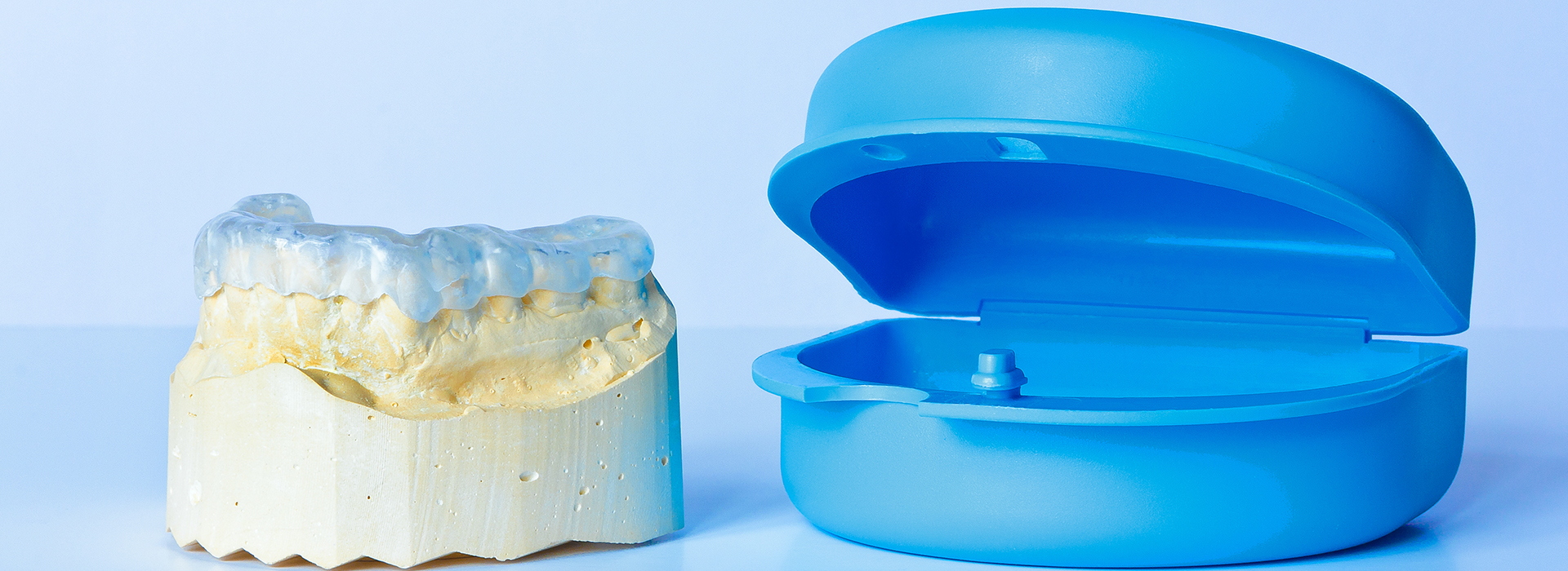 The image shows a blue toothbrush head next to a yellow toothpaste tube.
