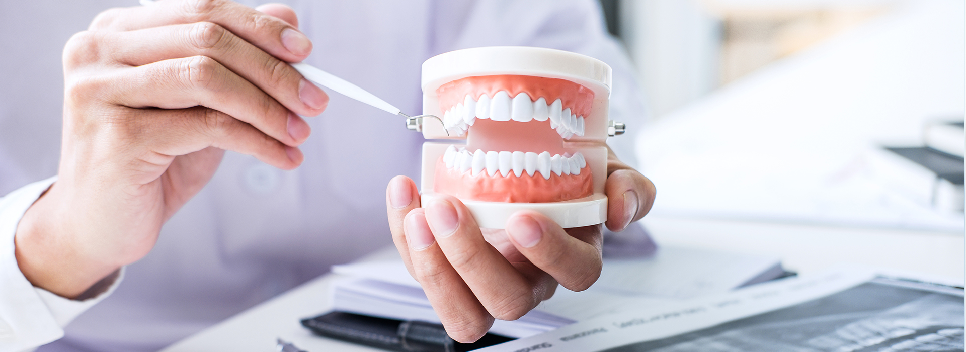 The image shows two hands holding a toothbrush over a cup with toothpaste, while another hand holds a smartphone with a toothbrush app displayed on its screen.