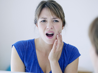 The image shows a woman with her mouth open, appearing to be speaking or singing, with a surprised or expressive facial expression.