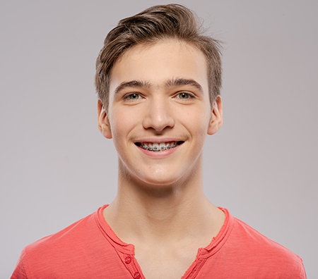 The image shows two side-by-side photographs of a young man with a smile, featuring a clean shave, wearing red t-shirts, against a white background.